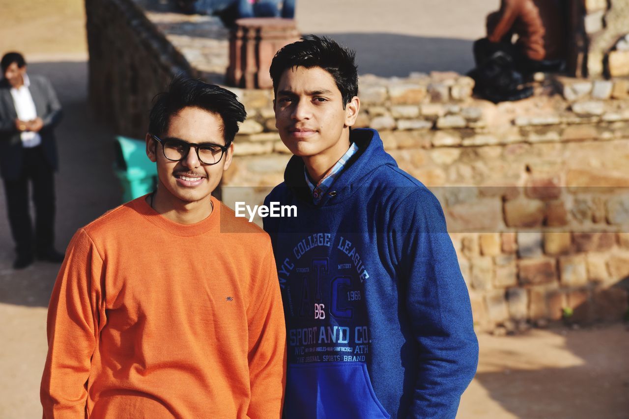 Portrait of friends standing against old ruins