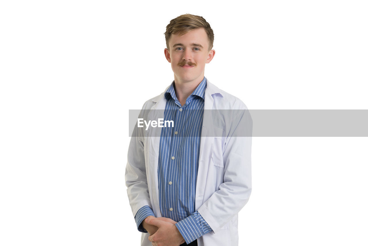 Portrait of doctor standing against white background