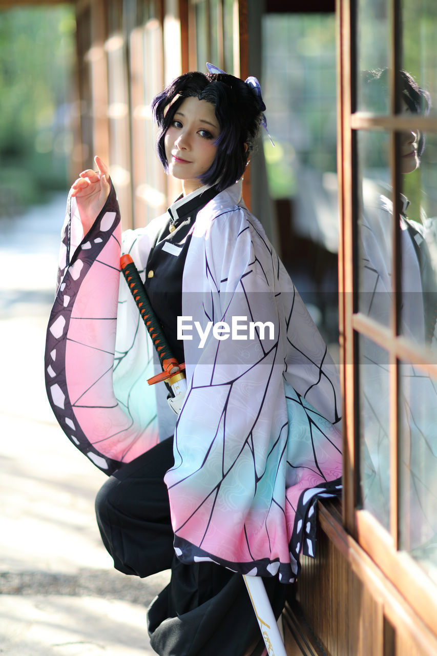 side view of young woman standing by railing