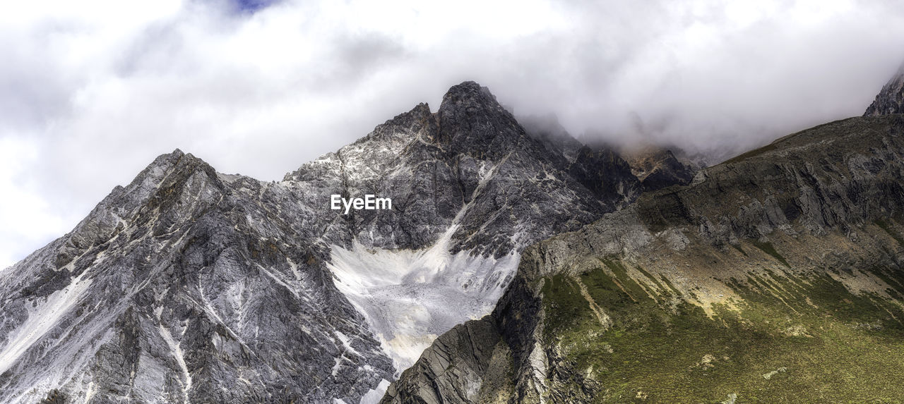 Low angle view of rocky mountain against sky
