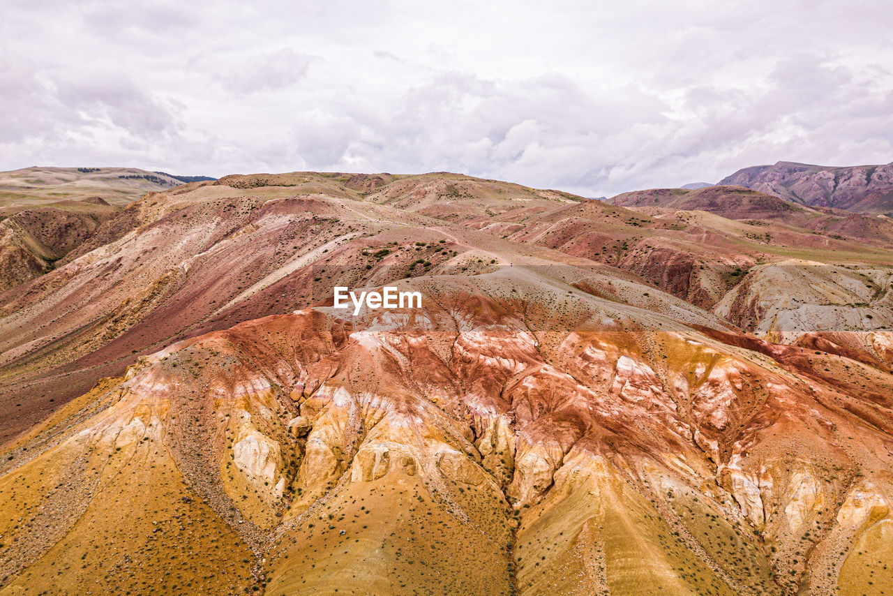 A stunning panorama of a mountain chain of peaks, a canyon with red clay, top view. 