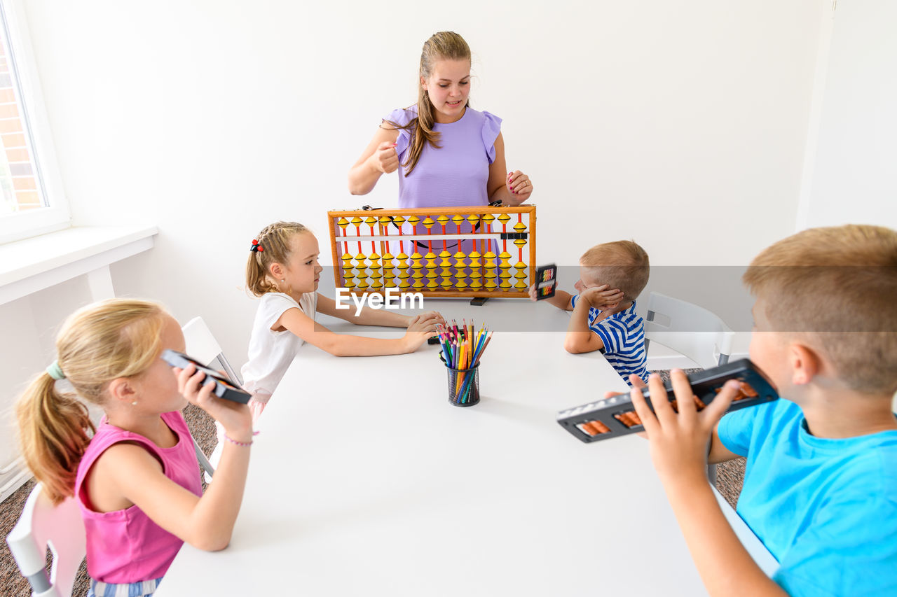 Group of children doing playful exercises with their therapist. learning difficulty concept.