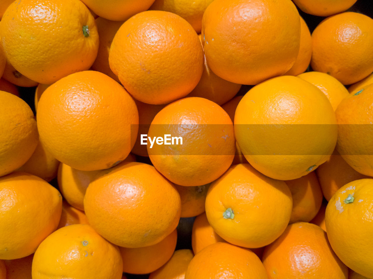 FULL FRAME SHOT OF ORANGES IN MARKET FOR SALE