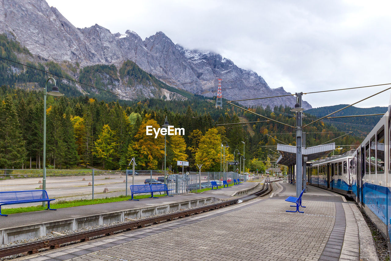 SCENIC VIEW OF RAILROAD TRACKS BY TREES AGAINST SKY