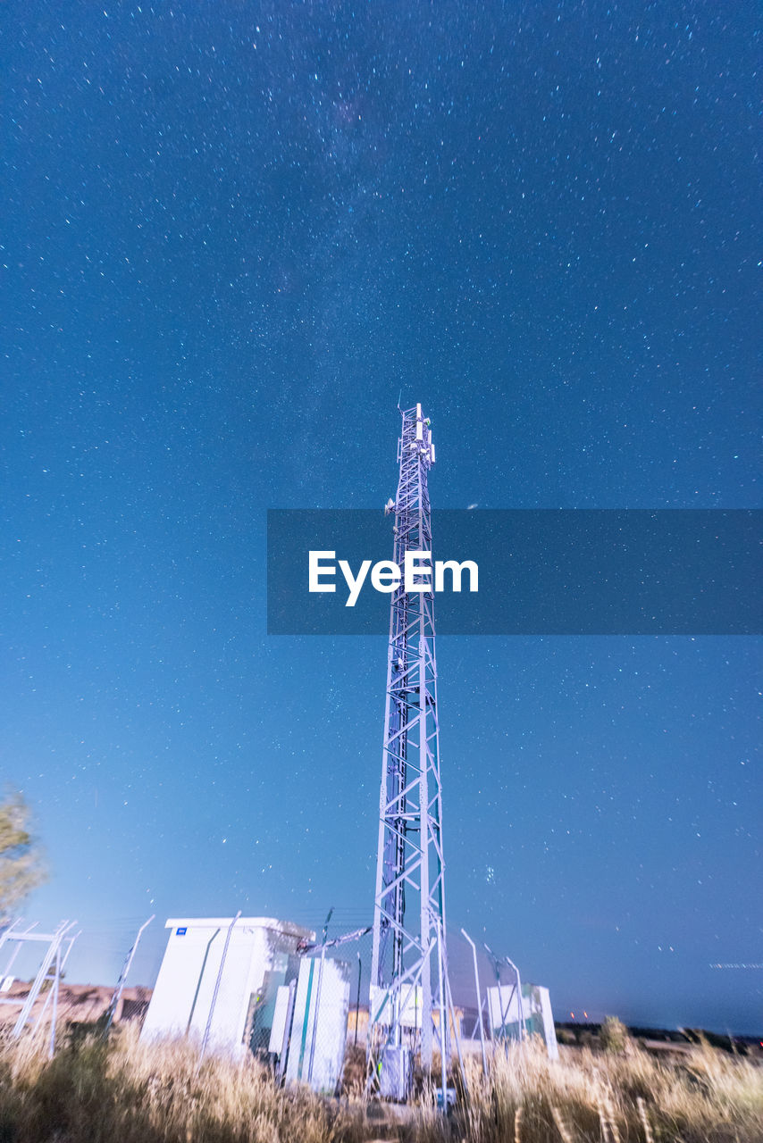 Low angle view of communications tower against blue sky