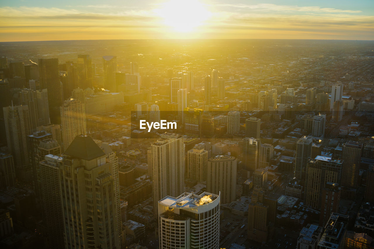 Aerial view of buildings against sky during sunset