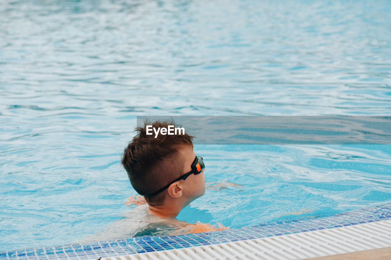 Side view of boy swimming in pool