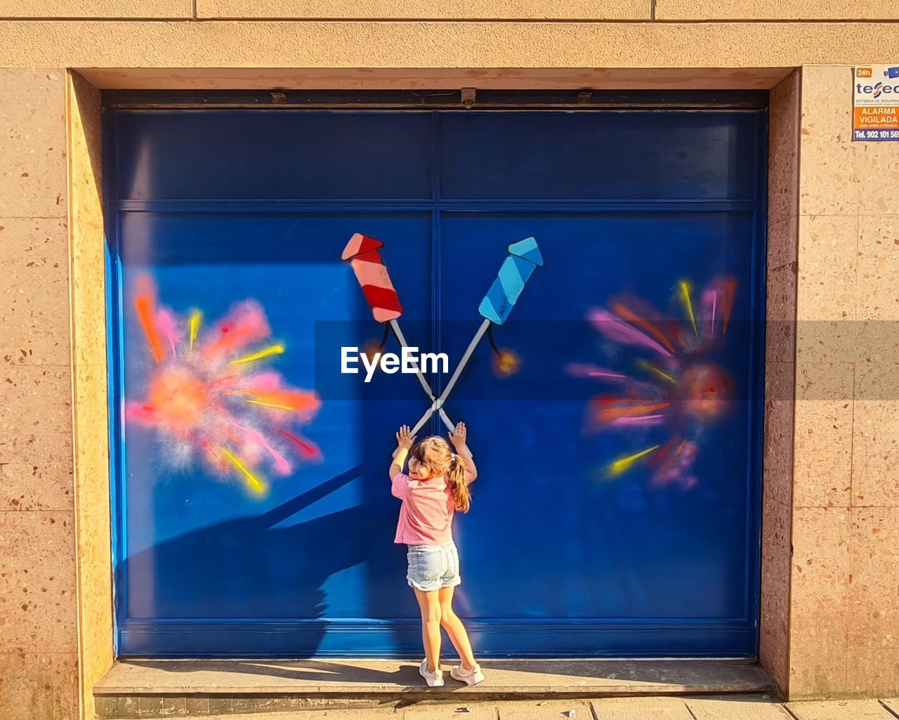 blue, wall, full length, one person, art, mural, child, childhood, painting, architecture, standing, nature, red, day, adult, fun, outdoors, creativity, wall - building feature, door, multi colored, women, holding, building exterior, window, female, men