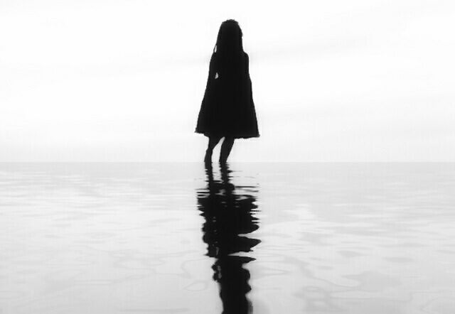 SILHOUETTE OF WOMAN STANDING ON BEACH