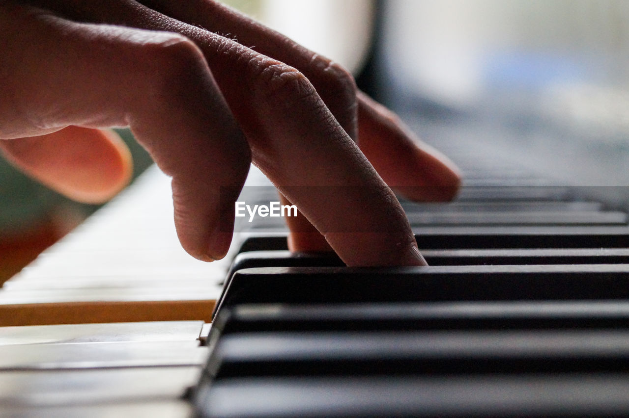 Cropped image of hands playing piano