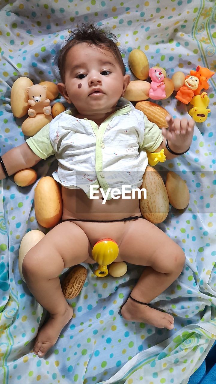 PORTRAIT OF CUTE BABY BOY ON BED