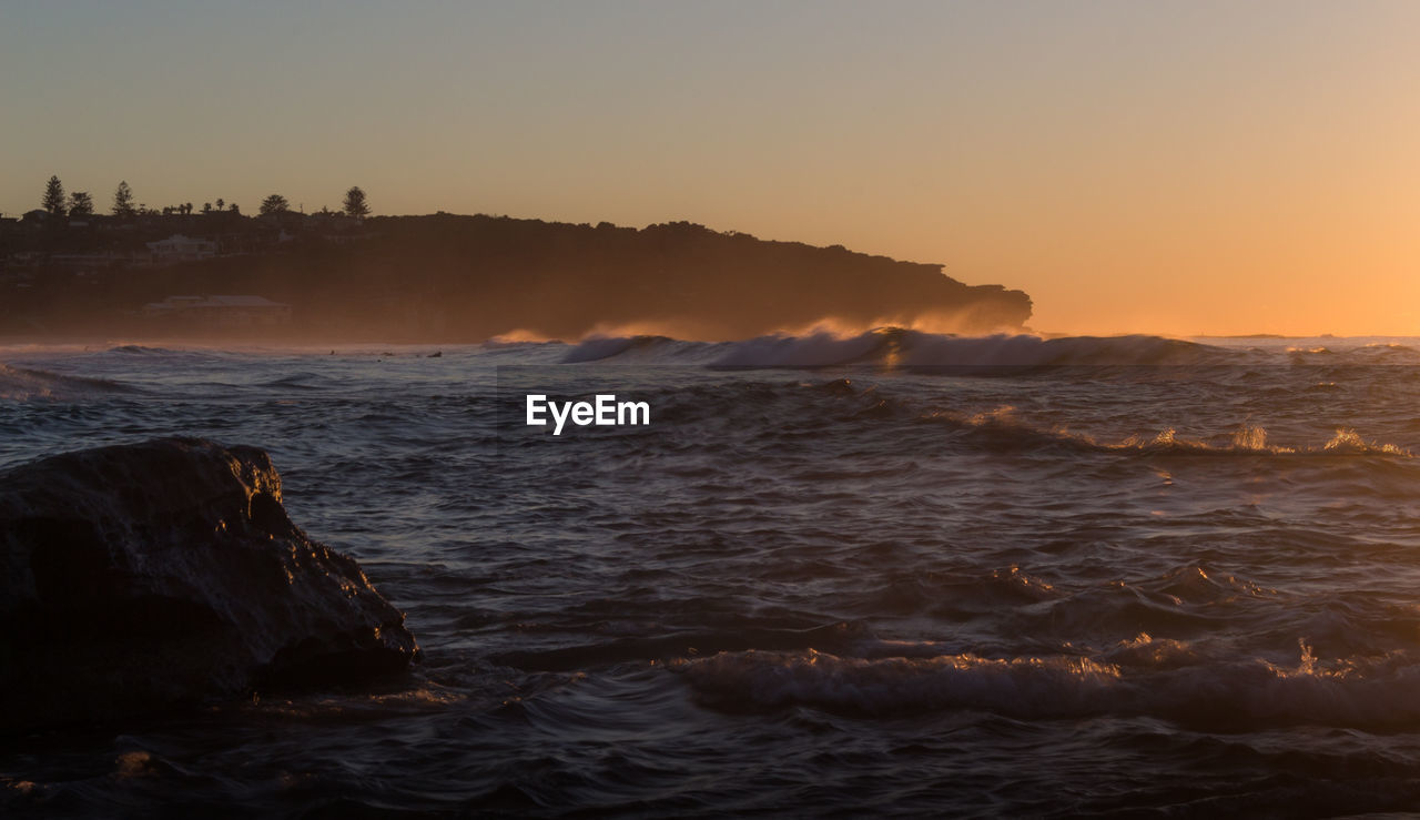 Scenic view of sea against clear sky during sunset