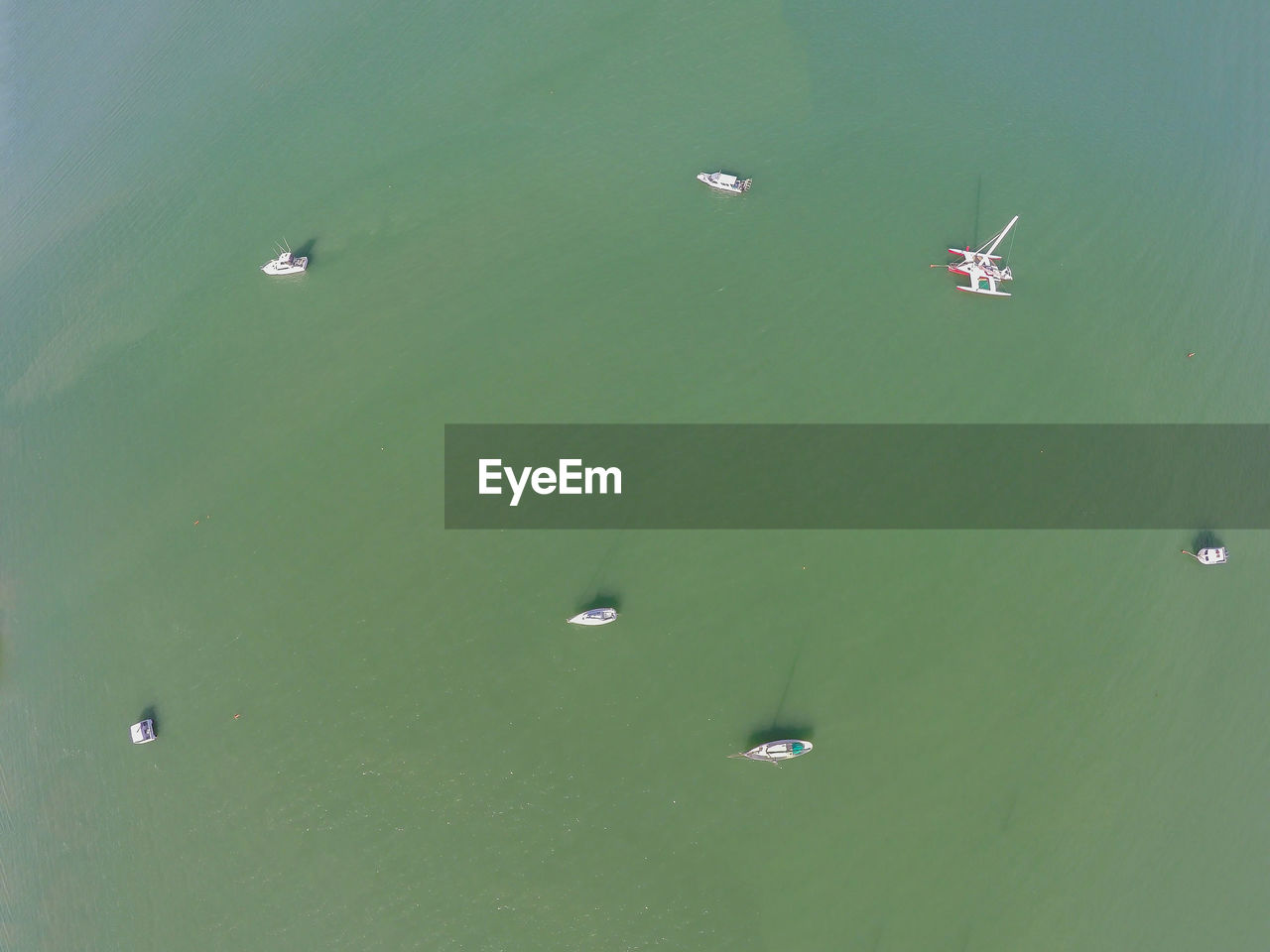 HIGH ANGLE VIEW OF HELICOPTER FLYING OVER BEACH