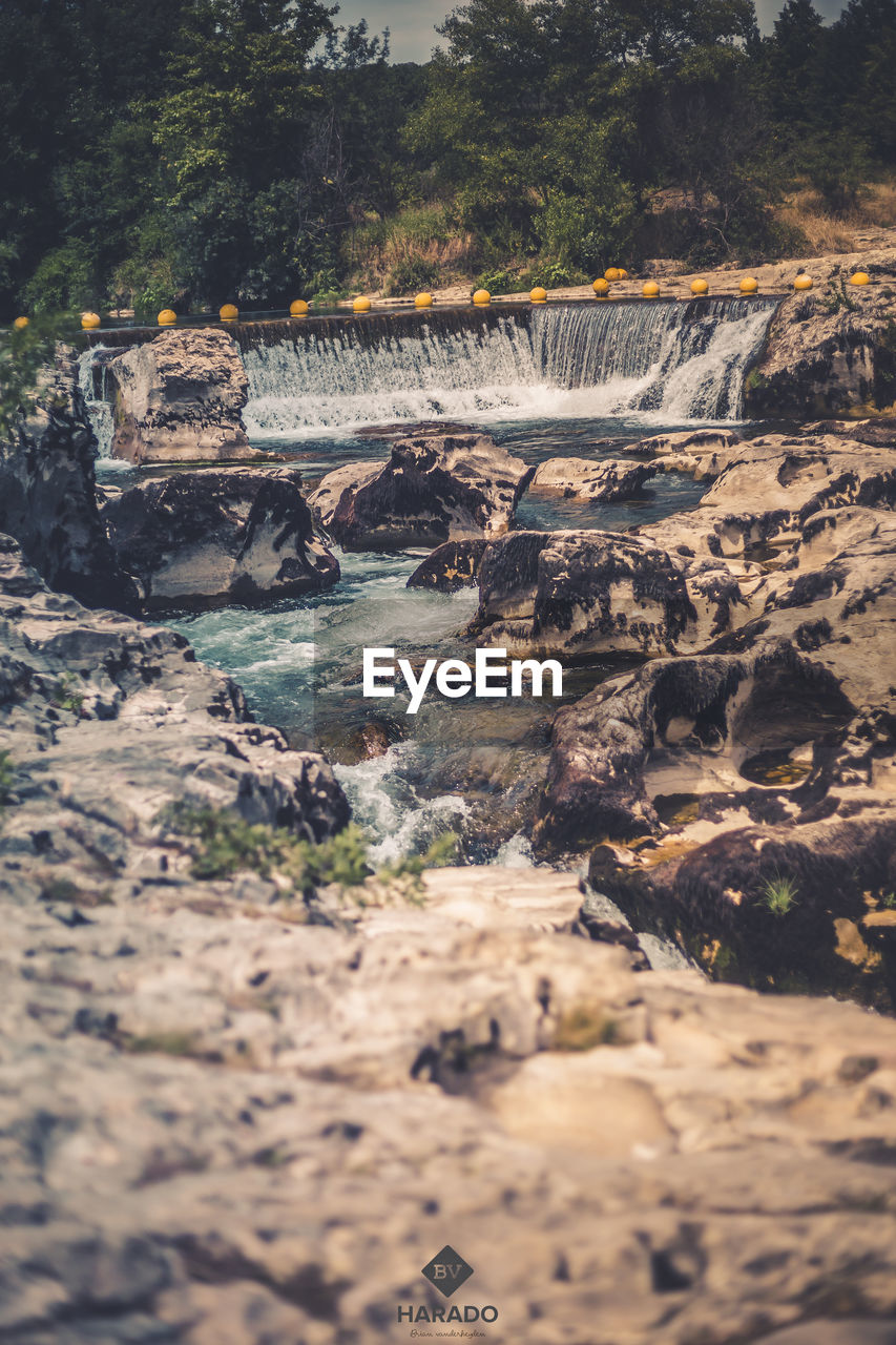 VIEW OF ROCKS AND TREES IN WATER