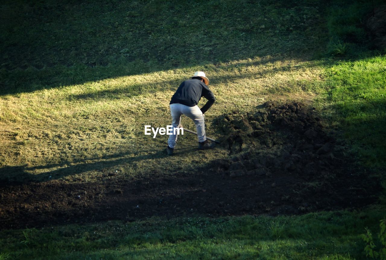 REAR VIEW OF MAN ON FIELD