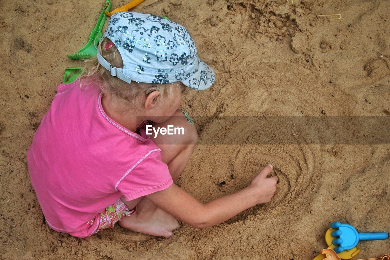 High angle view of girl playing on sand at beach