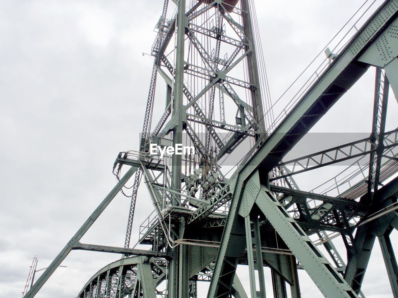 LOW ANGLE VIEW OF FERRIS WHEEL AGAINST CLOUDY SKY