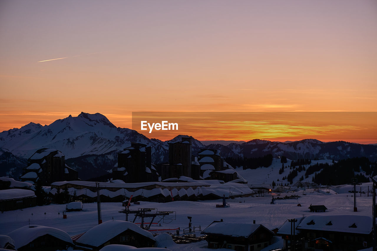 Scenic view of snowcapped mountains against sky during sunset