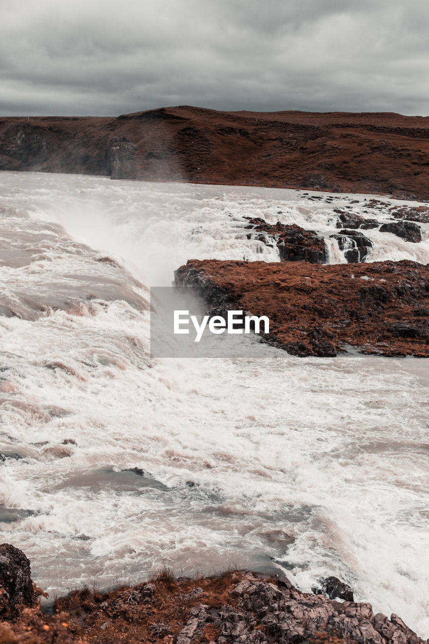 Scenic view of rocks in water against sky