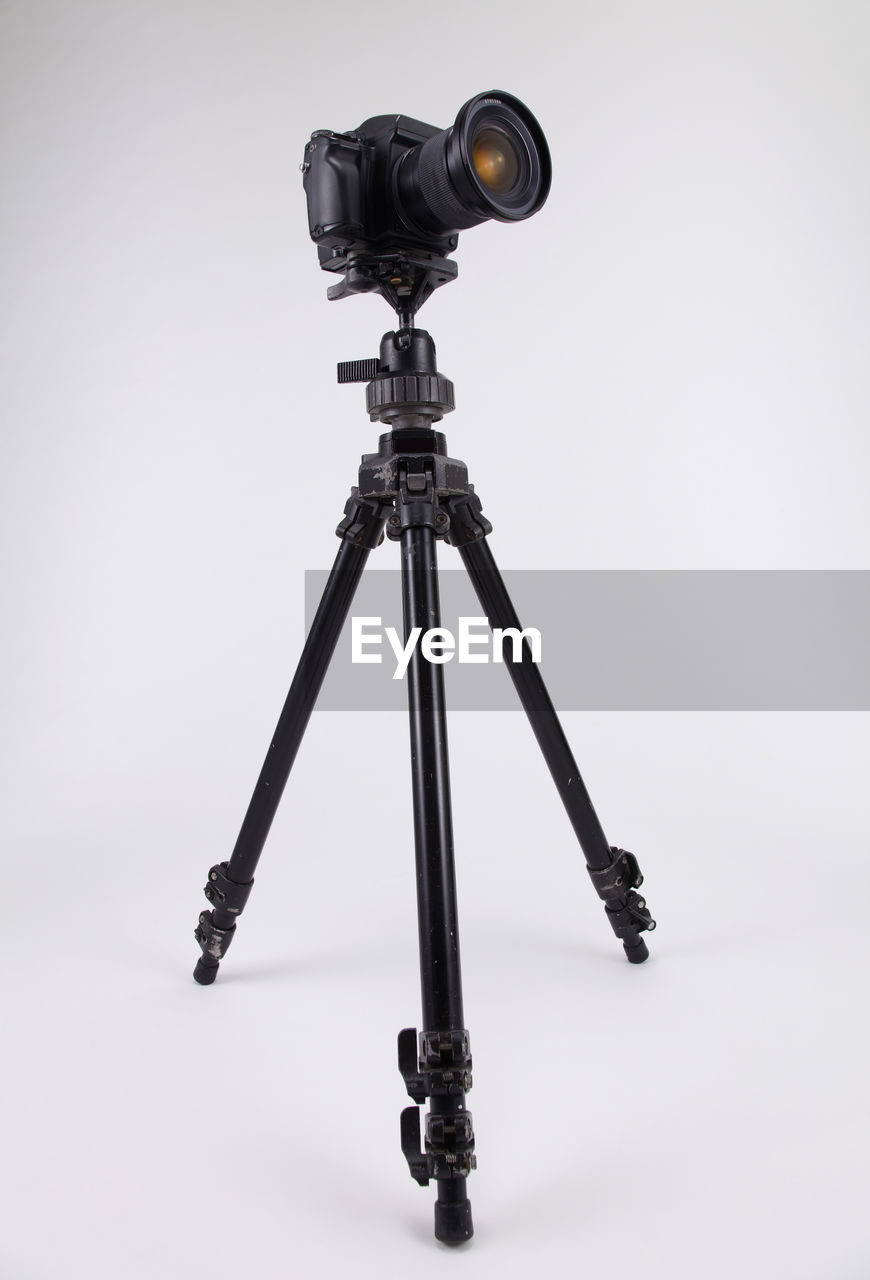 LOW ANGLE VIEW OF CAMERA AGAINST GRAY BACKGROUND