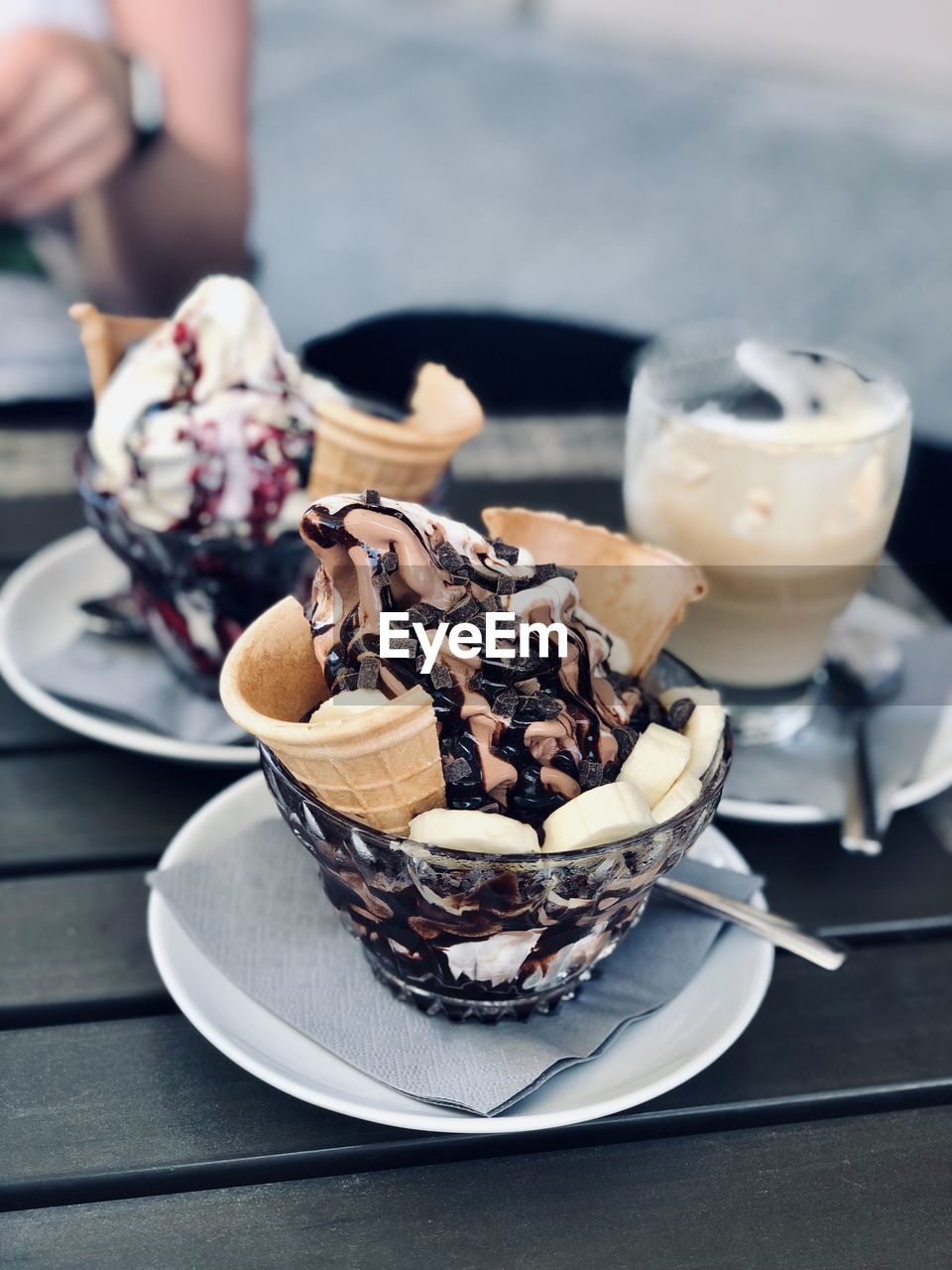 Midsection of person with ice cream in plate on table