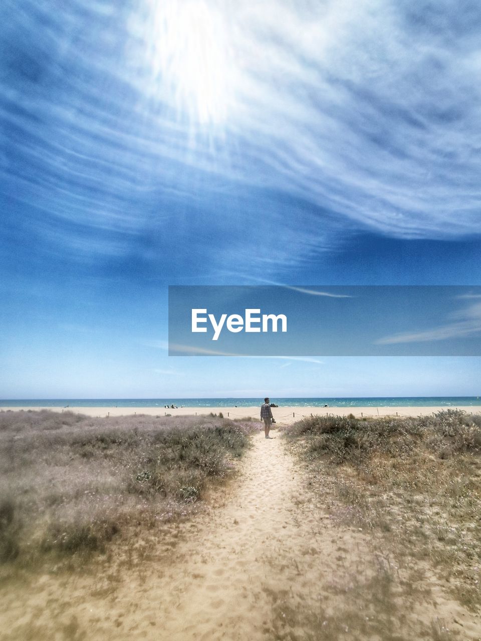 Mid distance of man standing at beach against sky