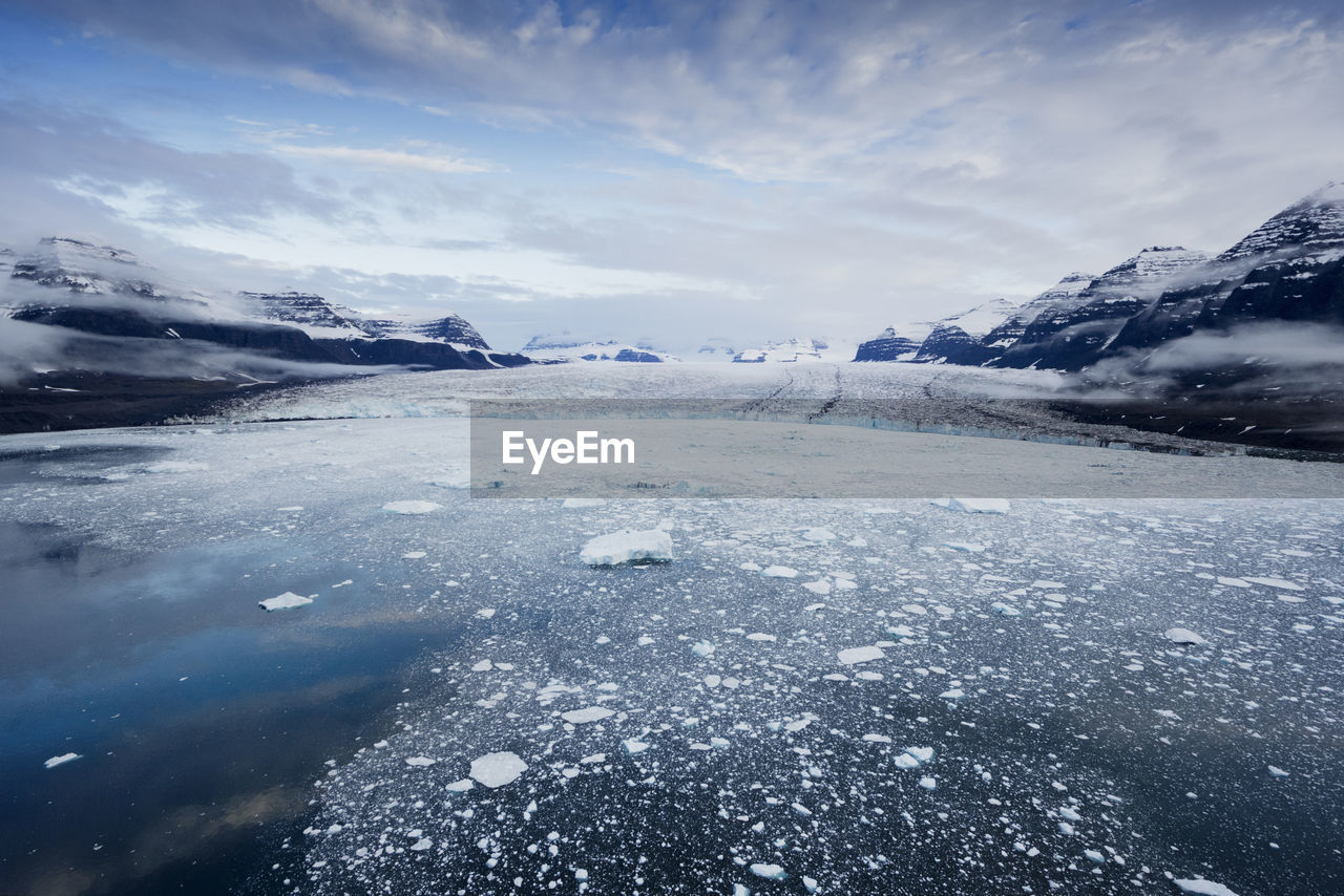 Scenic view of landscape against cloudy sky during winter