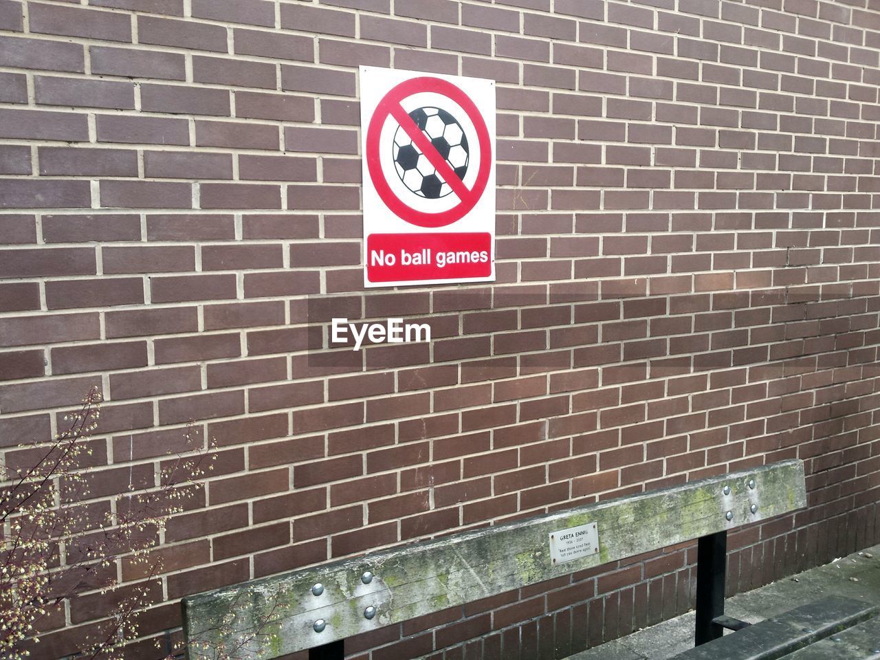 Warning sign on brick wall