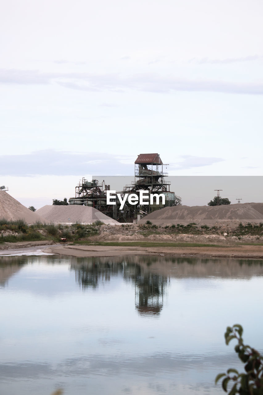 BUILT STRUCTURE ON LAKE AGAINST SKY