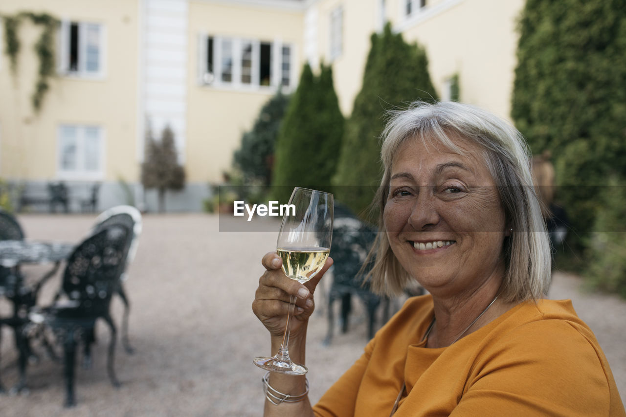 Smiling woman holding glass of wine