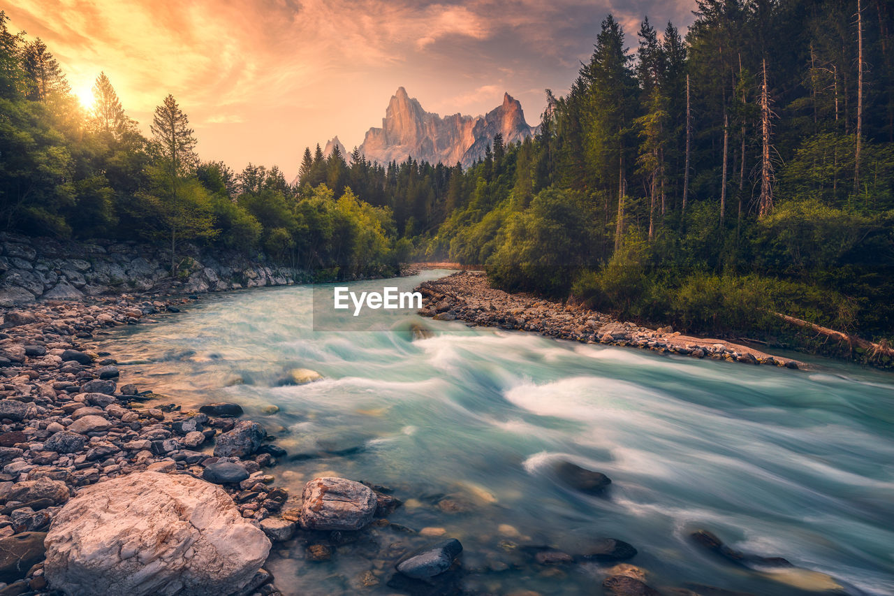 Scenic view of waterfall against sky during sunset