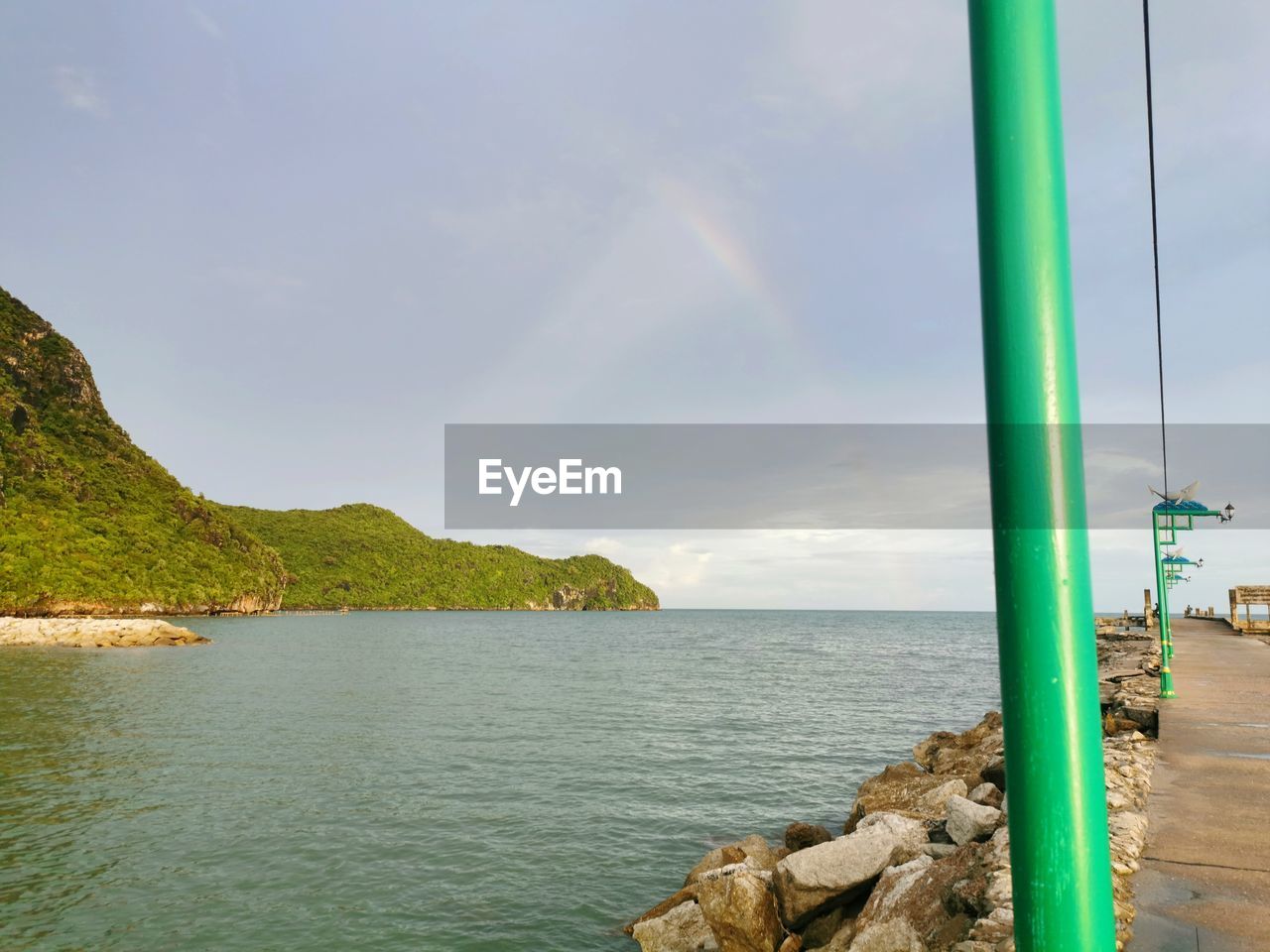 Scenic view of sea against rainbow in sky