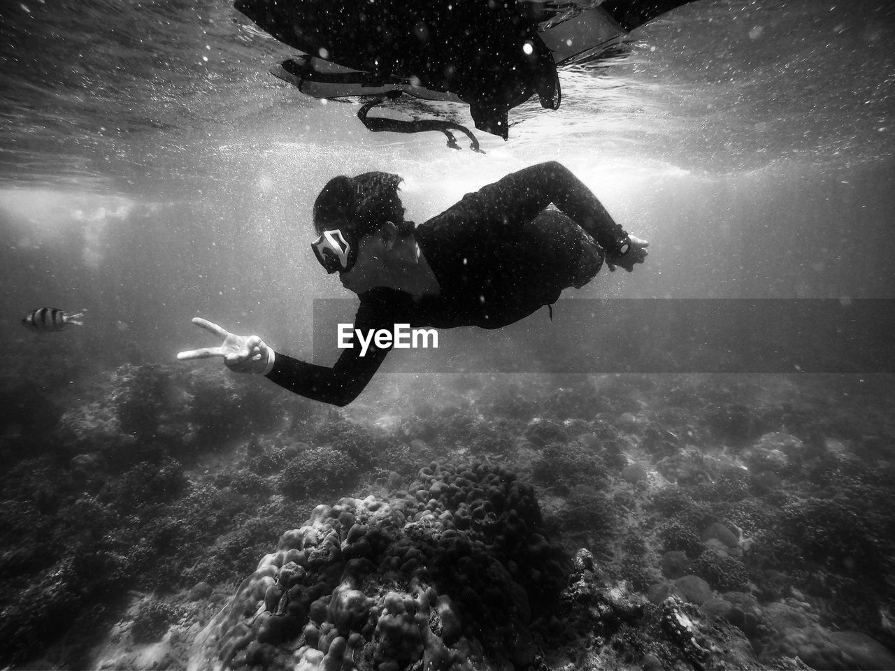 Man gesturing peace sign while swimming undersea