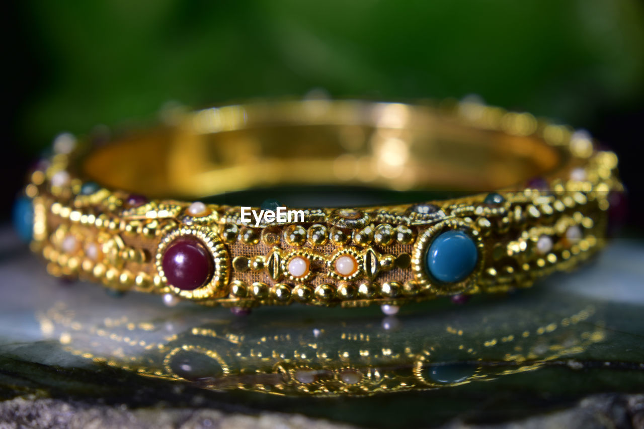 Close-up of gold bangle on table