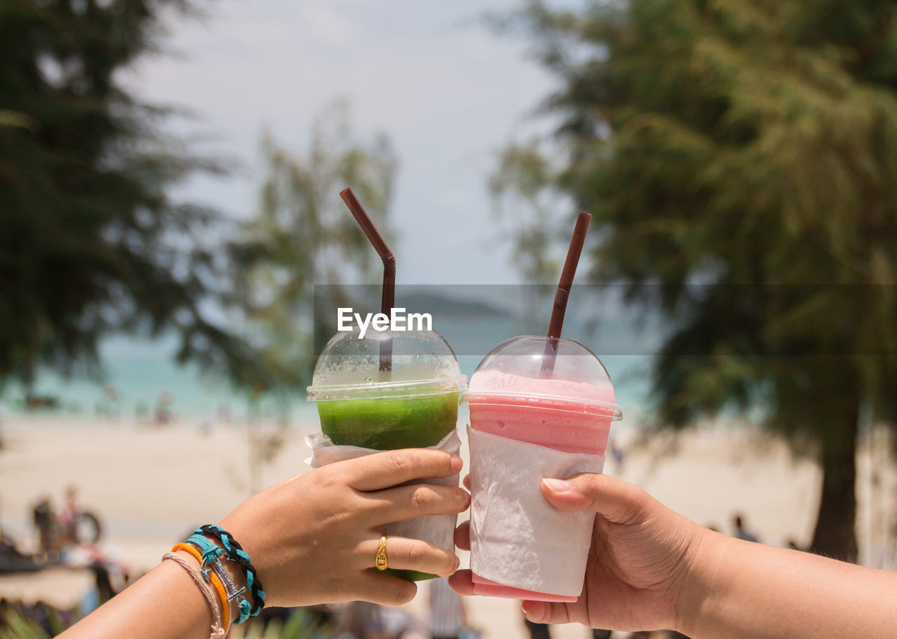 Close-up of people toasting drinks outdoors