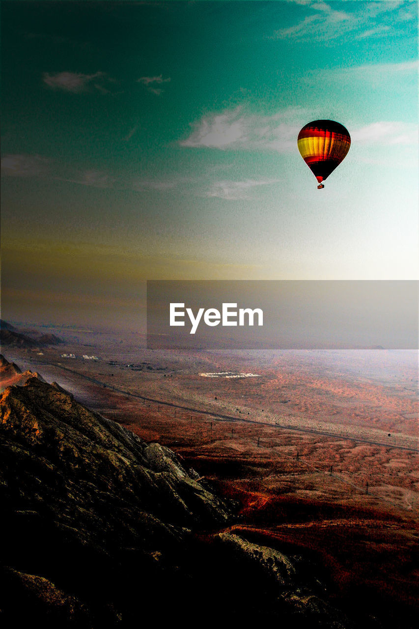 AERIAL VIEW OF HOT AIR BALLOON FLYING OVER LANDSCAPE