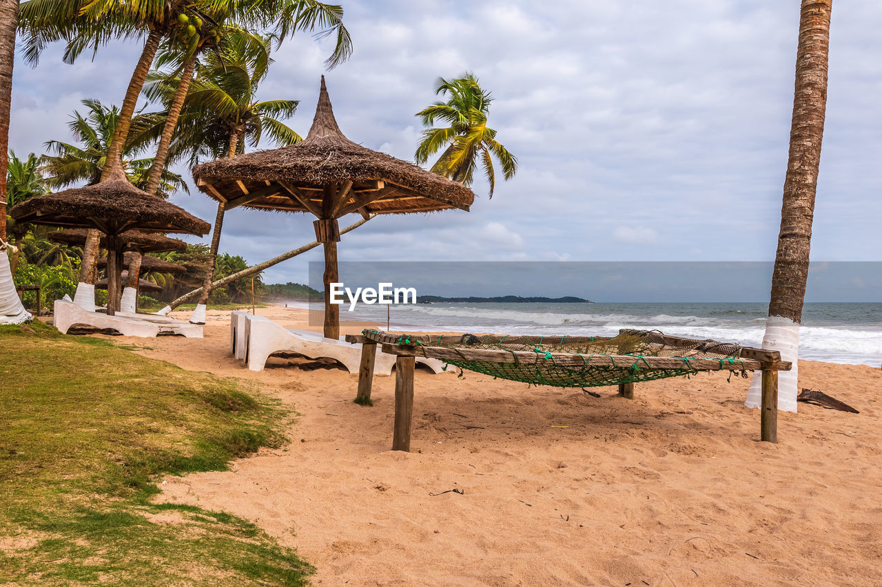 Axim beach with coconut palm trees and sunbeds lying on the gold coast of ghana west africa.