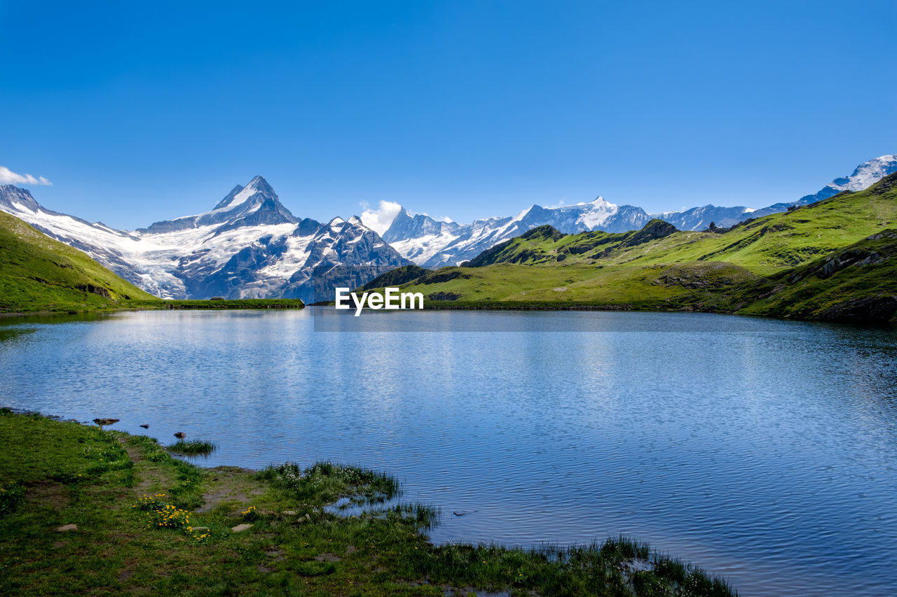 SCENIC VIEW OF LAKE BY MOUNTAINS AGAINST SKY