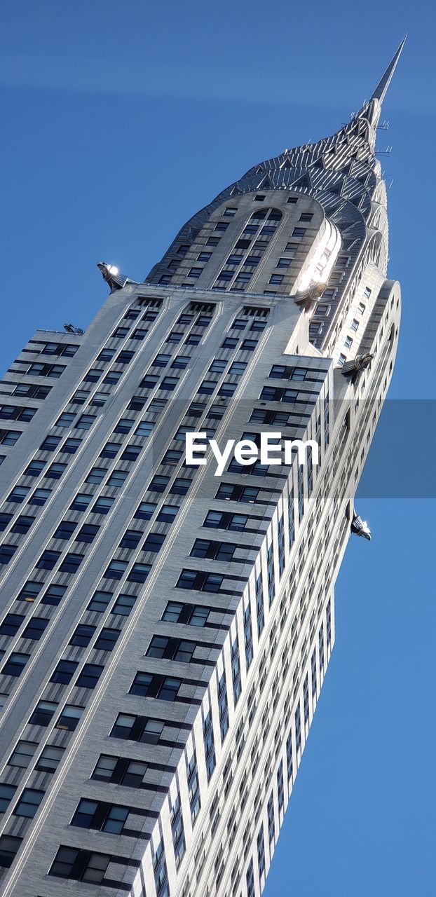 LOW ANGLE VIEW OF BUILDINGS IN CITY AGAINST CLEAR BLUE SKY