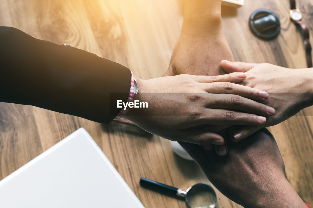 Business colleagues stacking hands at office