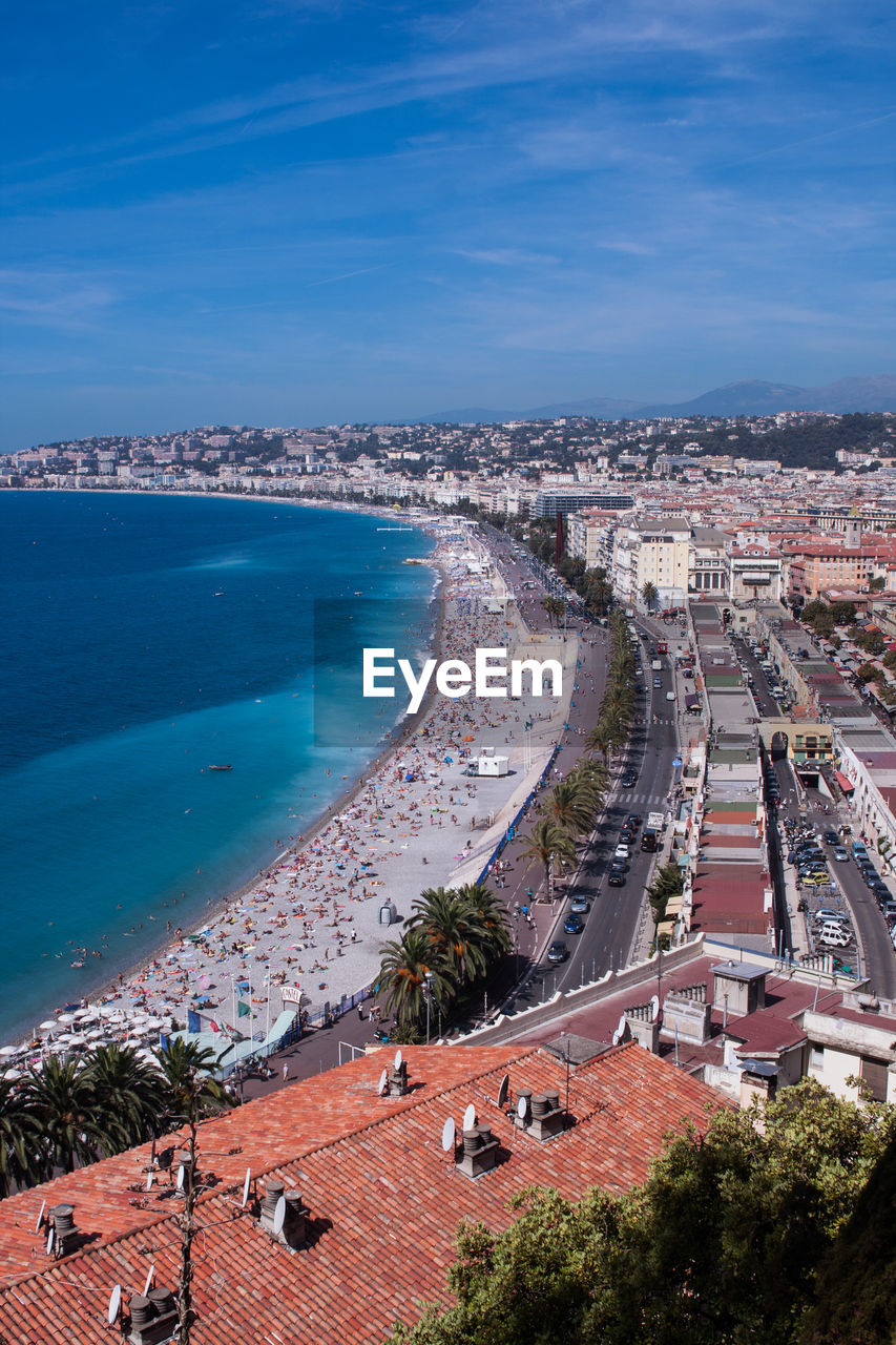 HIGH ANGLE VIEW OF SEA AND BUILDINGS AGAINST BLUE SKY