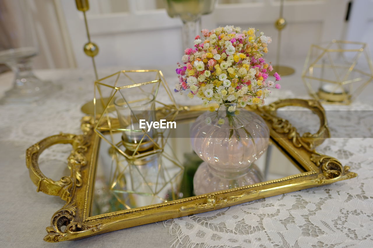 CLOSE-UP OF FLOWER VASE ON TABLE AGAINST WALL