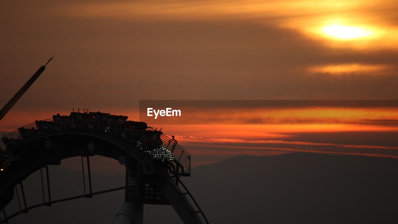 Silhouette of building against cloudy sky during sunset