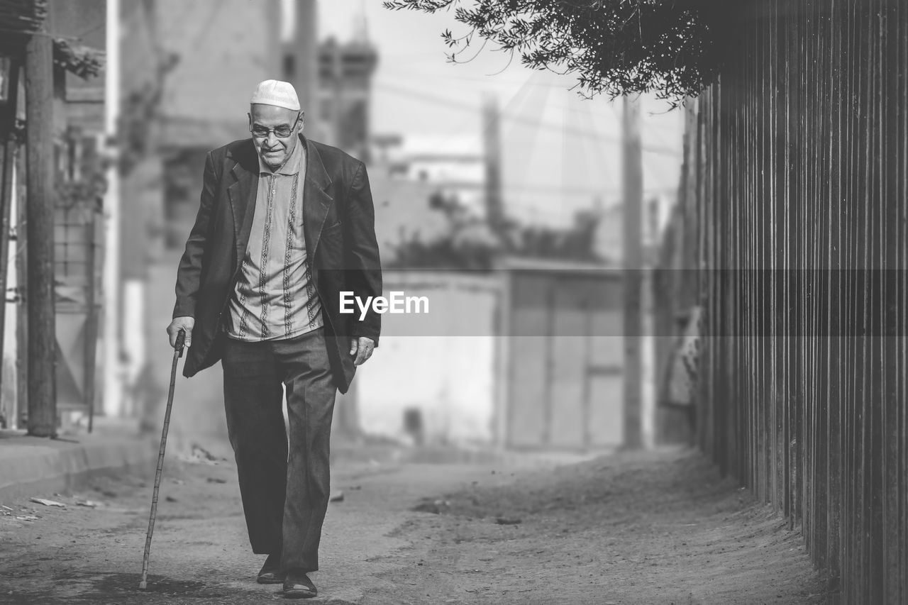 Full length of man walking with cane