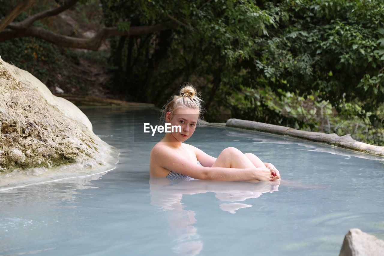 Portrait of young woman in pond