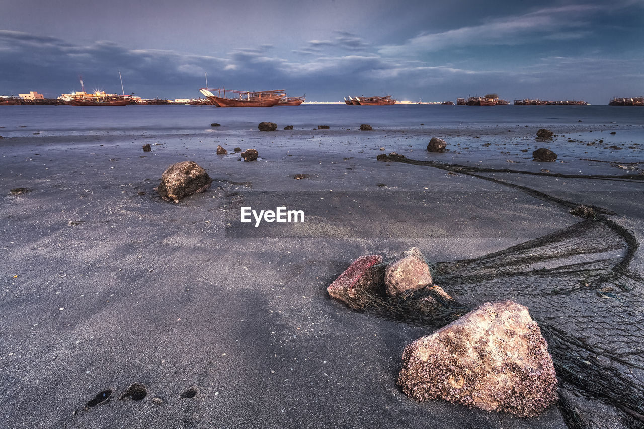 Scenic view of rocks on beach against sky