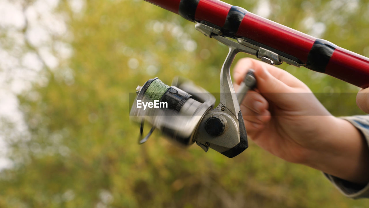 Cropped hand of man holding camera