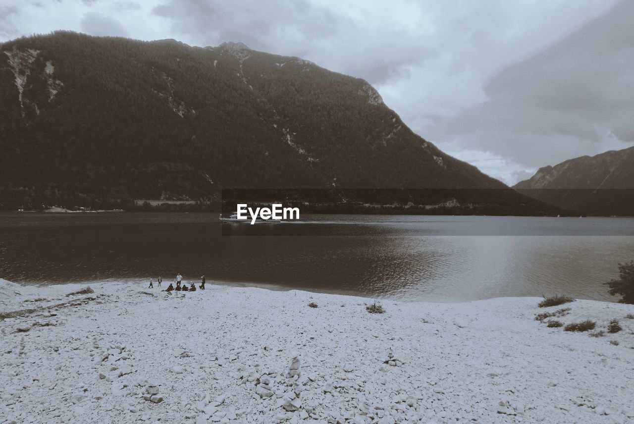 Scenic view of lake by mountains against sky