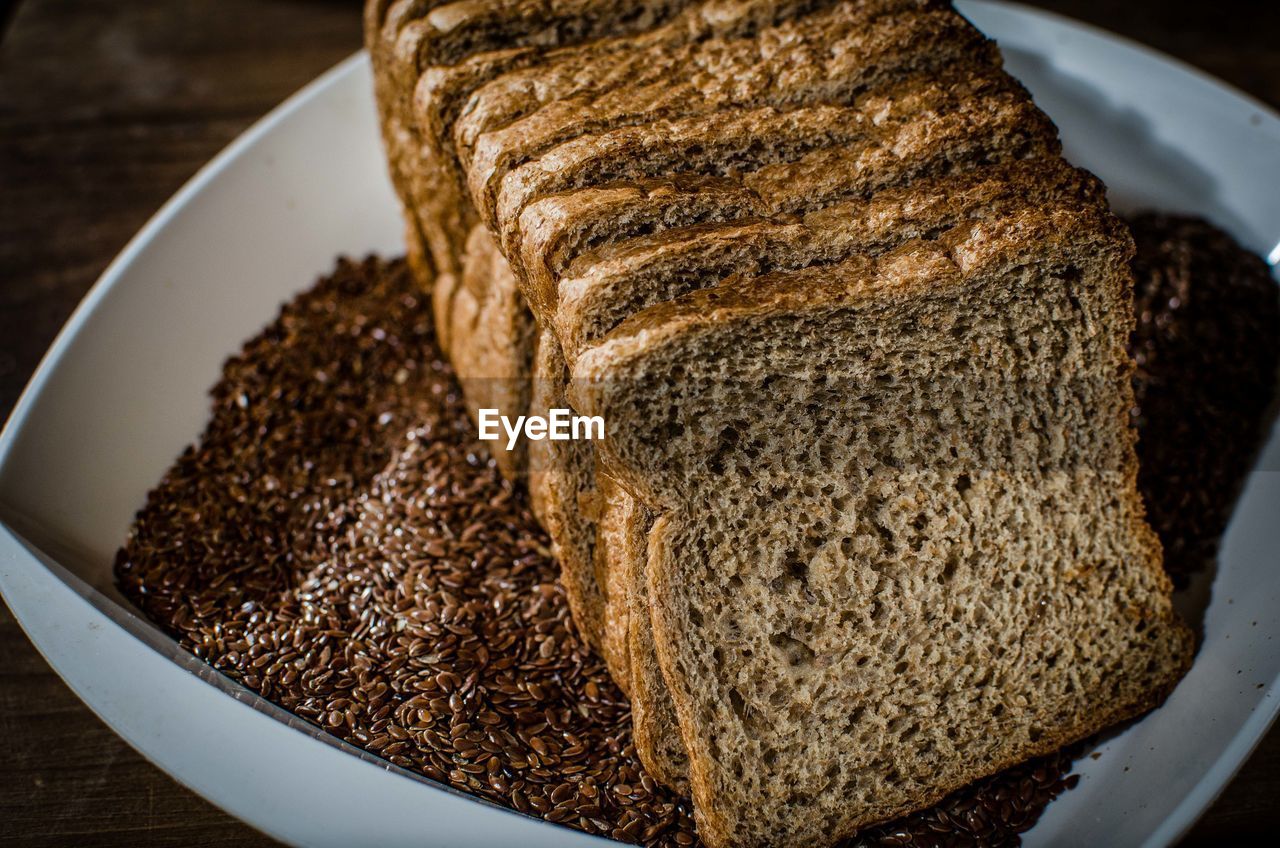 High angle view of brown breads with grain in plate