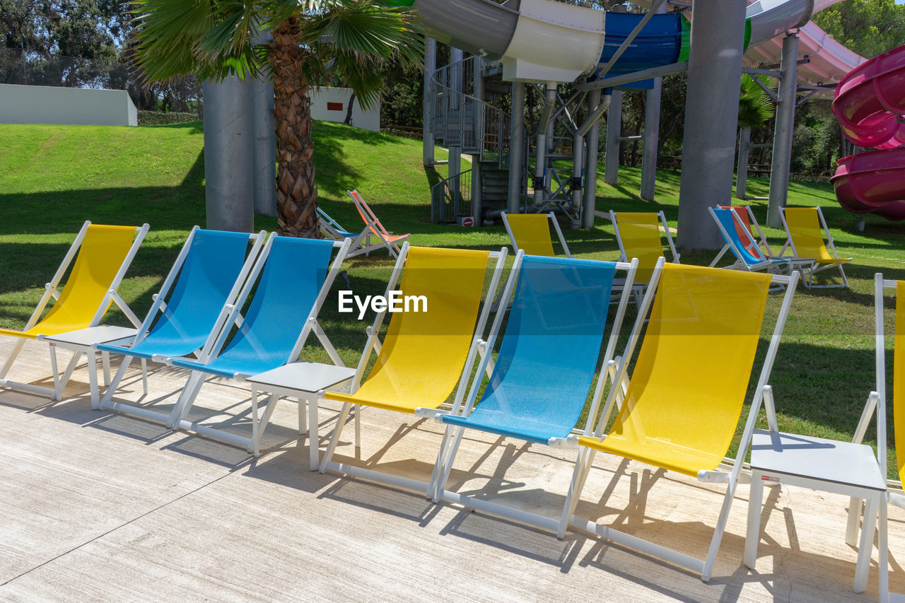 CHAIRS AND TABLES IN SWIMMING POOL AGAINST TREES